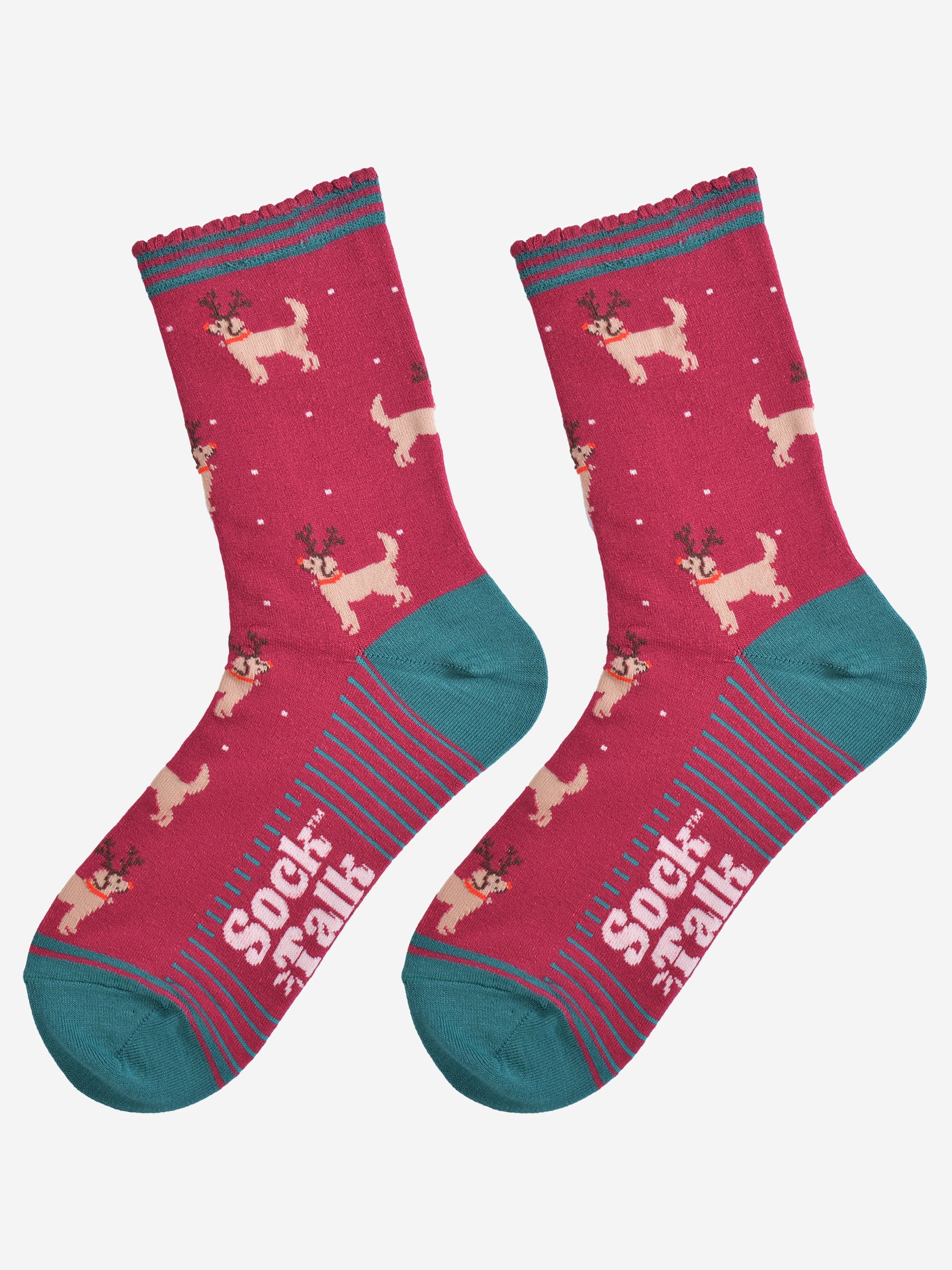 showing the golden retriever socks laying flat, the soles have green stripes, the dog pattern is all over the socks and there are also subtle falling snowflakes.