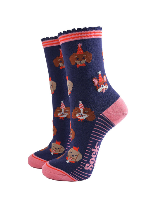 navy blue and pink ankle socks with a pattern of dogs wearing party hats and novelty glasses