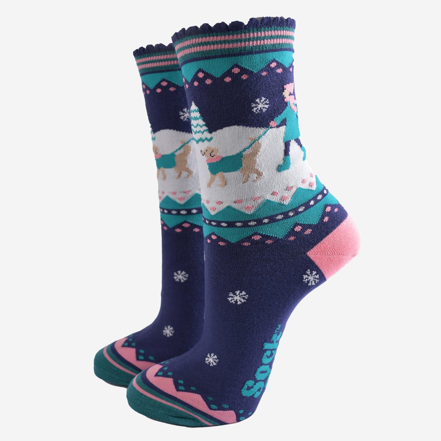 navy blue, pink and teal ankle socks featuring a snowy winter scene with a golden retriever dog taking its owner for a walk