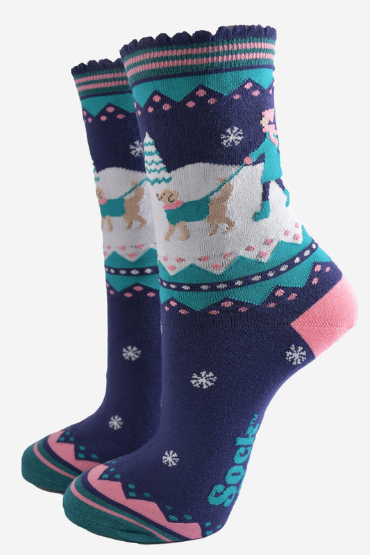 navy blue, pink and teal ankle socks featuring a snowy winter scene with a golden retriever dog taking its owner for a walk