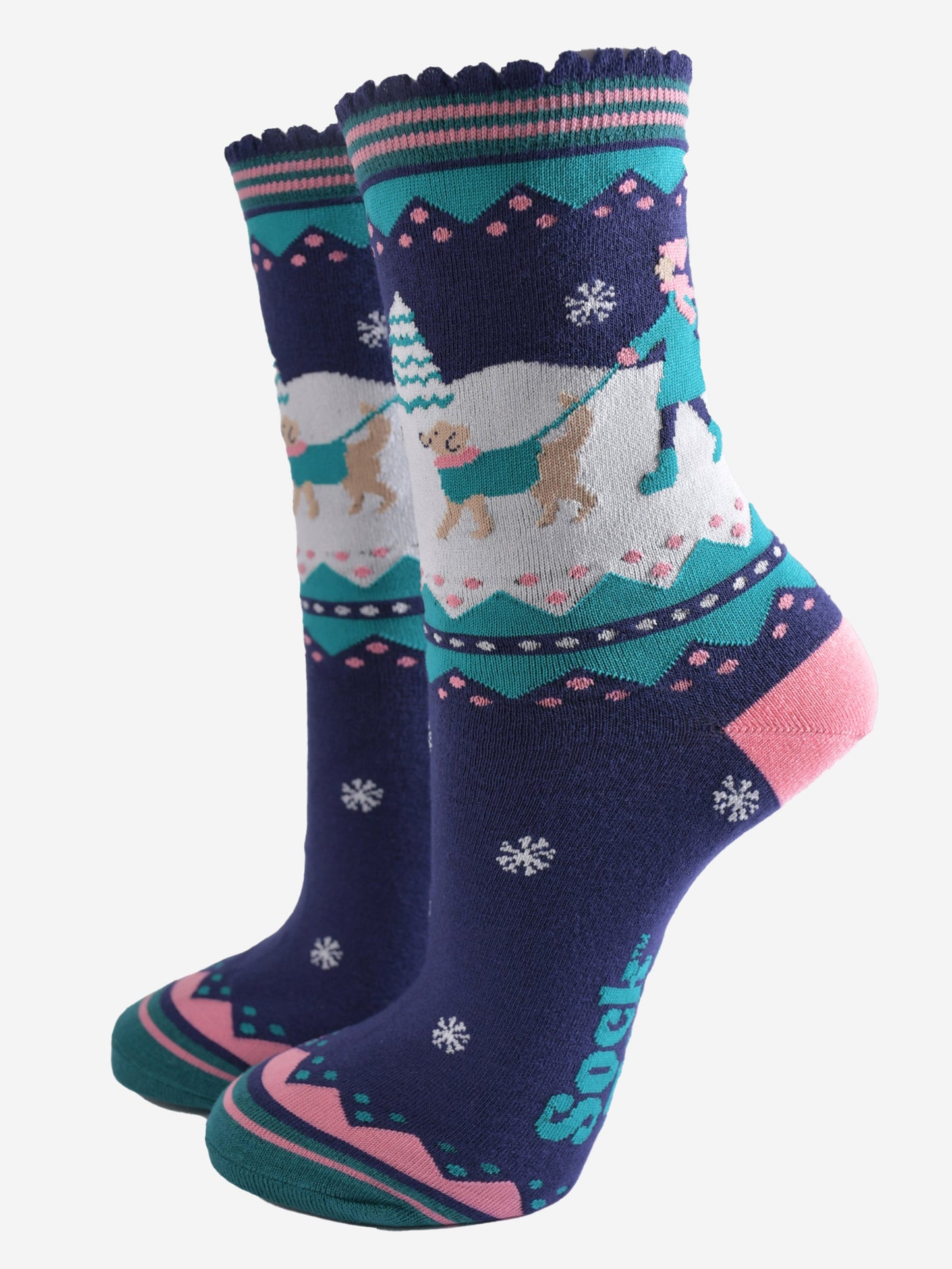 navy blue, pink and teal ankle socks featuring a snowy winter scene with a golden retriever dog taking its owner for a walk