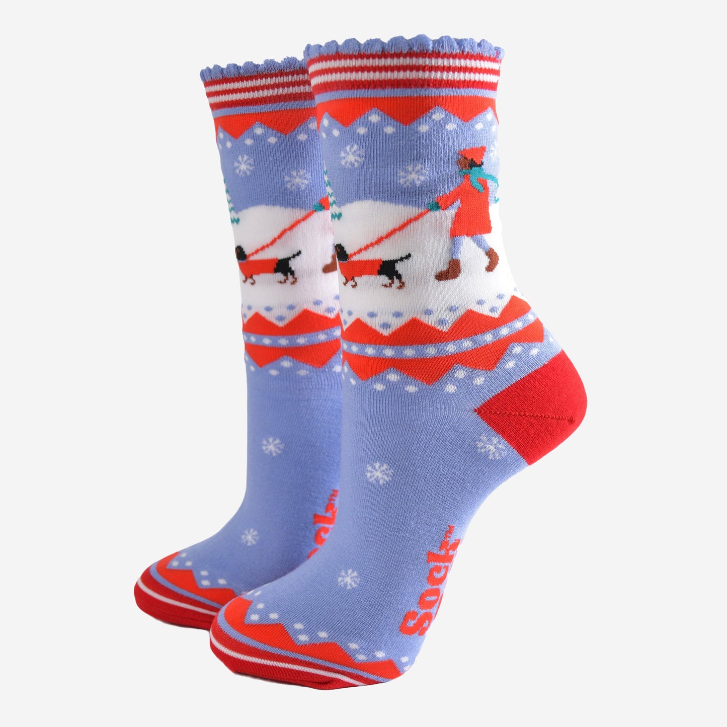 blue and red bamboo socks with a winter scene, showing a sausage dog and its owner taking a walk in the snow. 