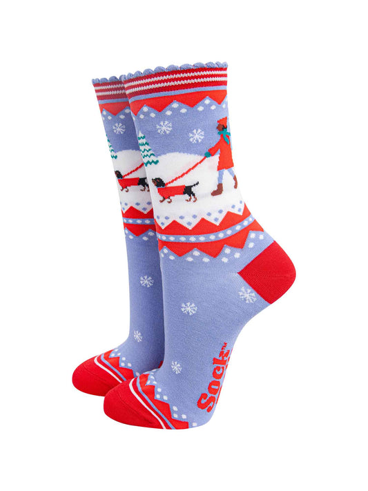 blue and red bamboo socks with a winter scene, showing a sausage dog and its owner taking a walk in the snow. 