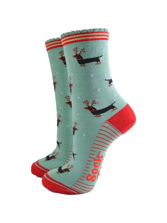 green and red ankle socks with a scalloped cuff and a pattern of dachshund dogs wearing reindeer antlers