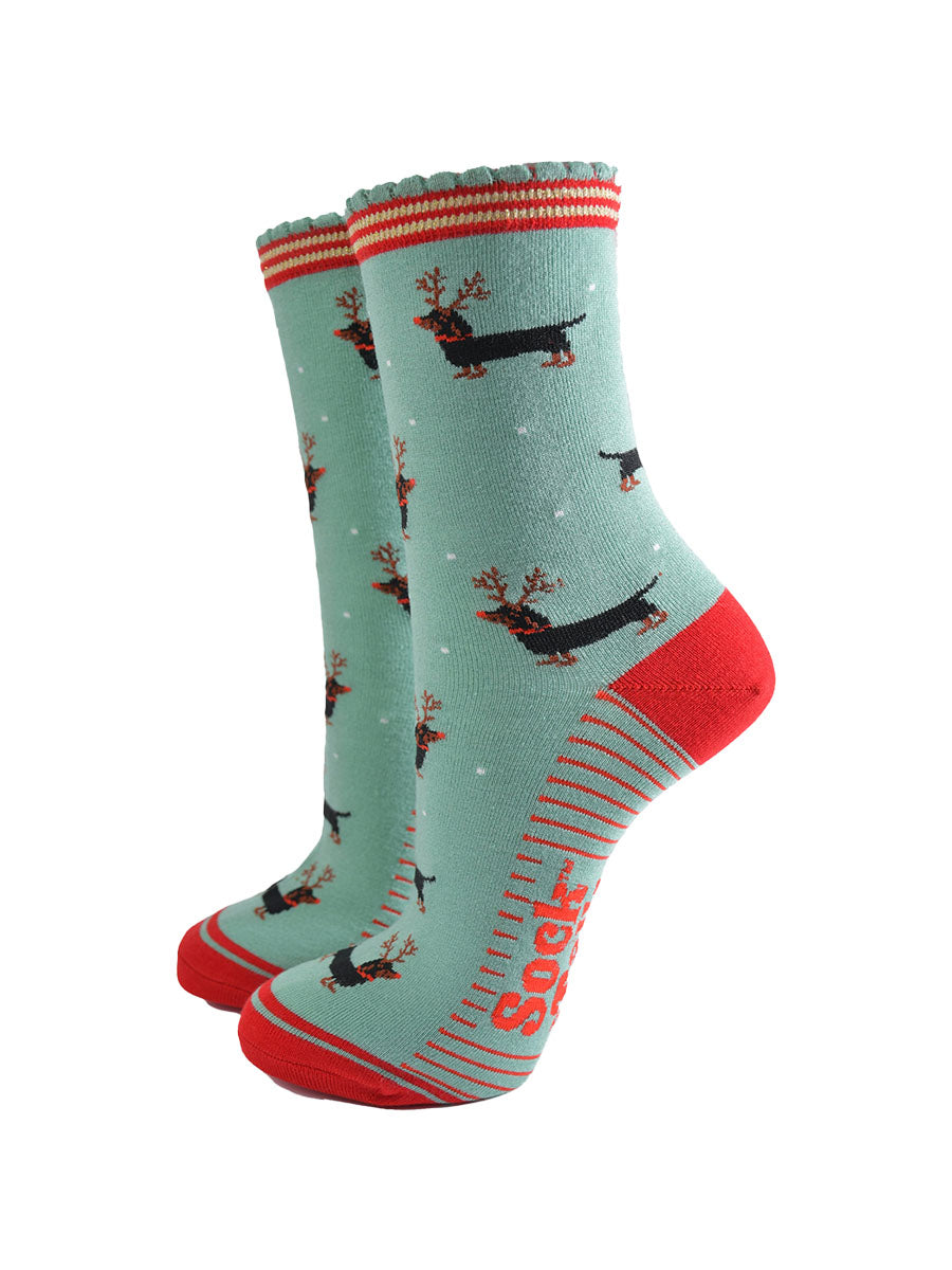 green and red ankle socks with a scalloped cuff and a pattern of dachshund dogs wearing reindeer antlers