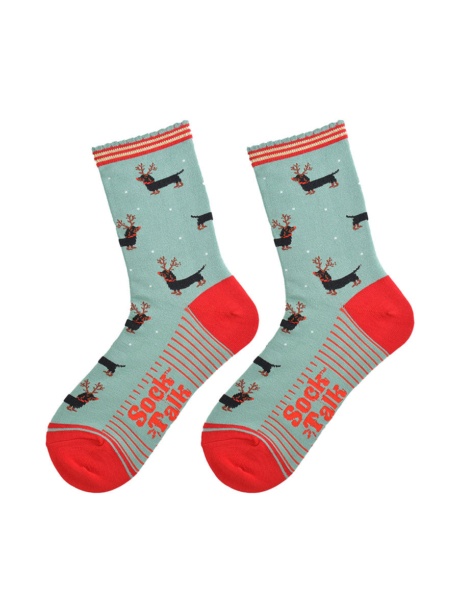 showing the sausage dog reindeer socks laying flat, the soles have red stripes and the dachshund dog pattern is shown to repeat all over the design.