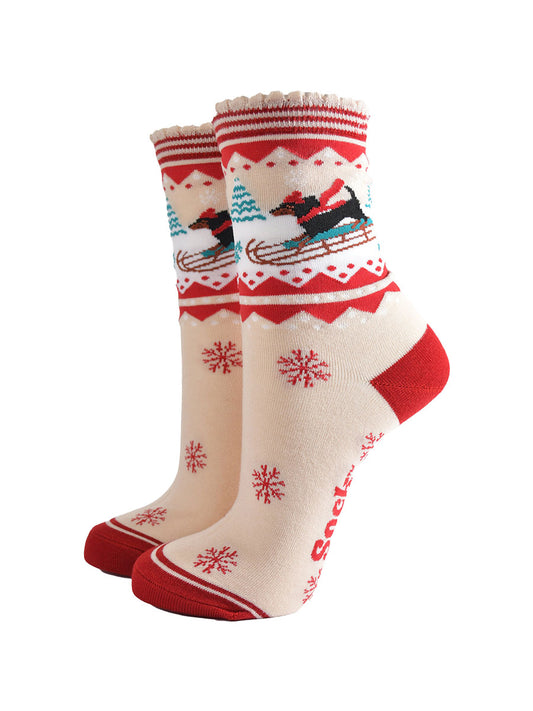 cream and red bamboo socks featuring a sledging sausage dog and red snowflake pattern