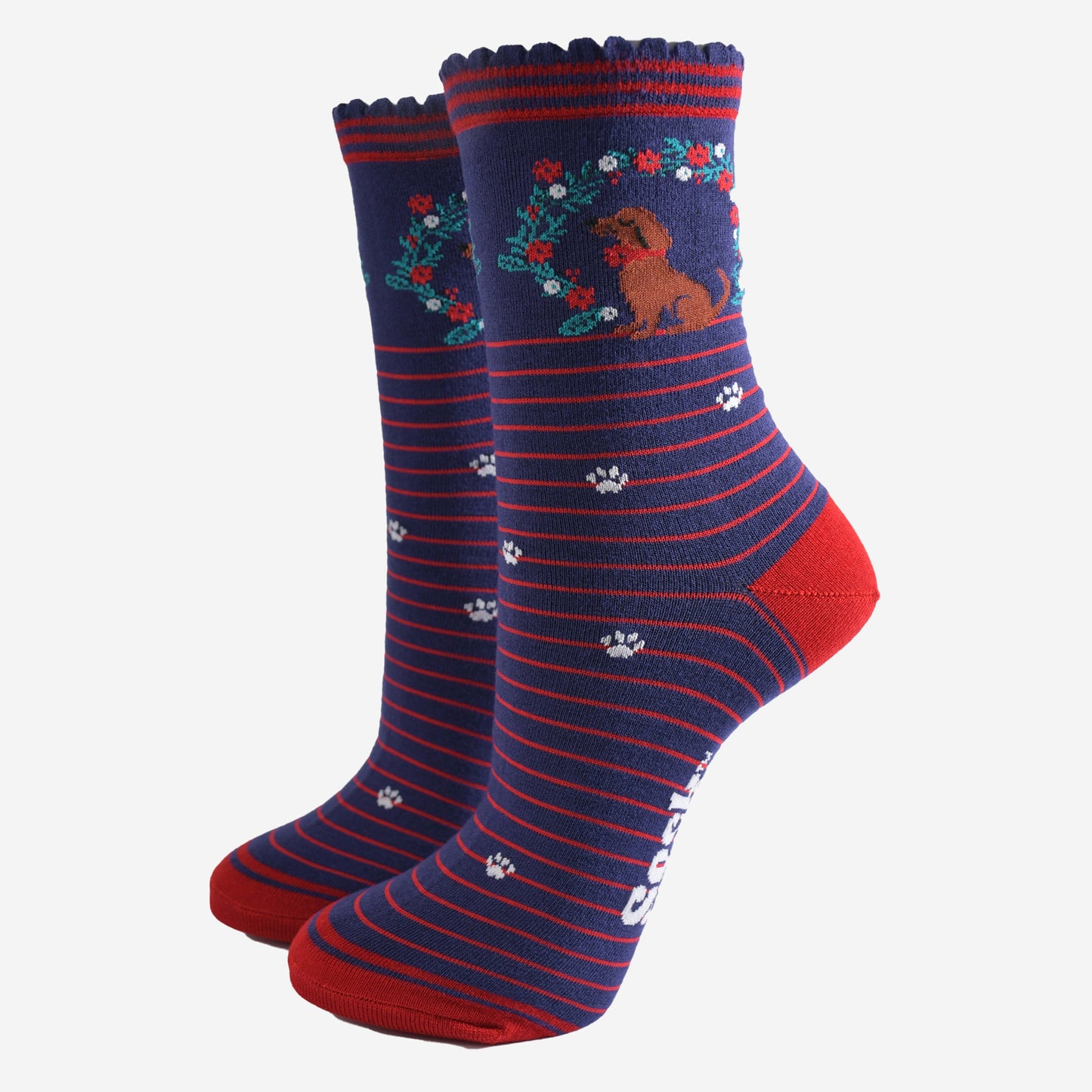 navy blue socks with red stripes, featuring a playful sausage dog and seasonal floral wreath