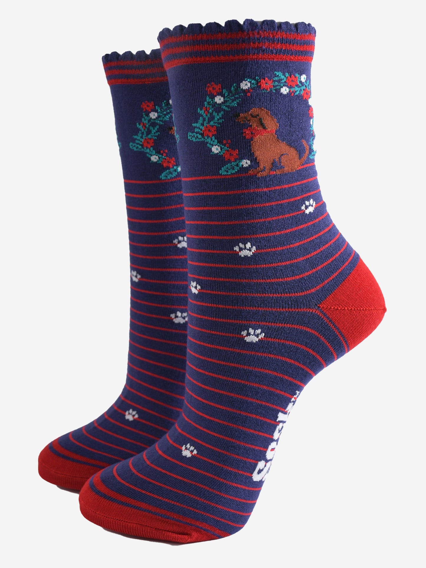 navy blue socks with red stripes, featuring a playful sausage dog and seasonal floral wreath