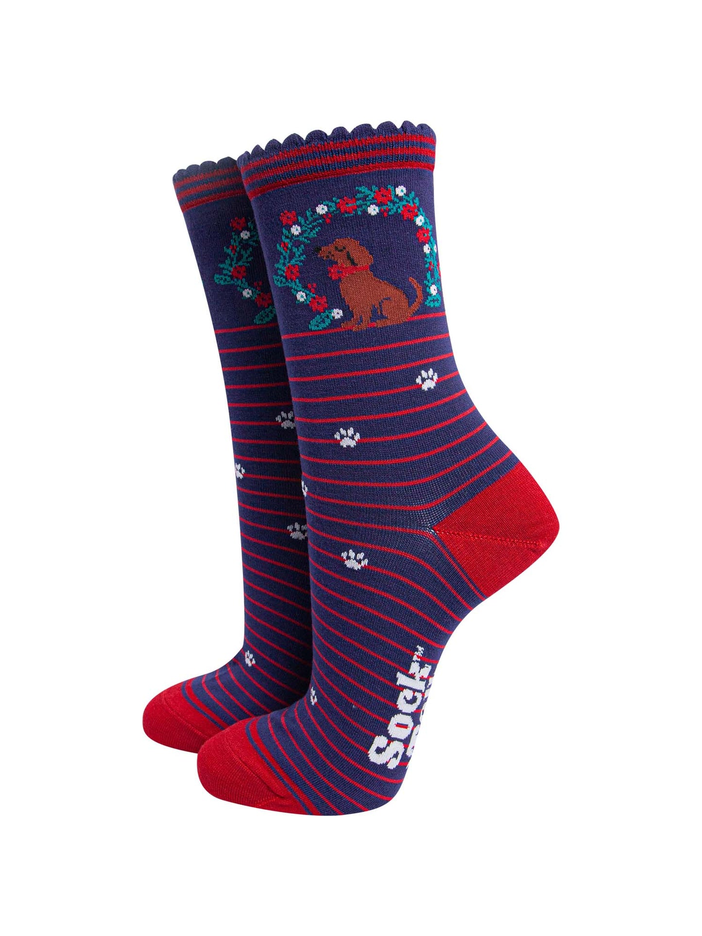 navy blue socks with red stripes, featuring a playful sausage dog and seasonal floral wreath