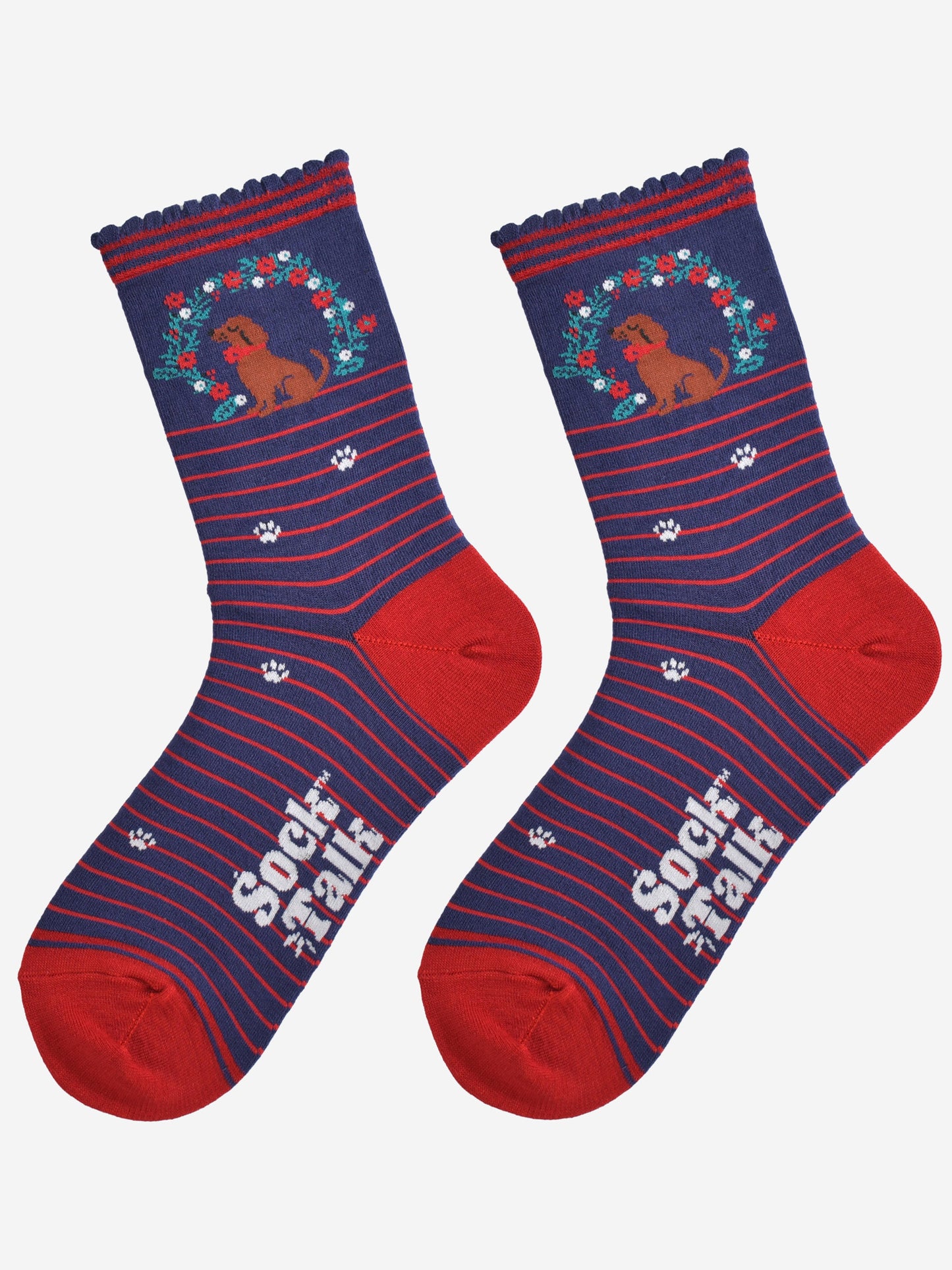 showing the socks laying flat, there is a red horizontal pinstripe throughout the socks except for the ankle where the sausage dog and wreath and located, there are white paw prints on the socks aswell