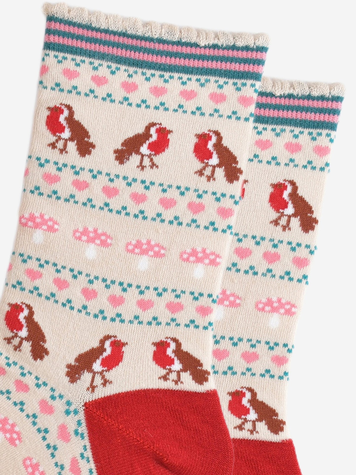 close up of the fair isle pattern, there are red robin birds, pink love hearts and pink toadstools in rows all separated by small green dots