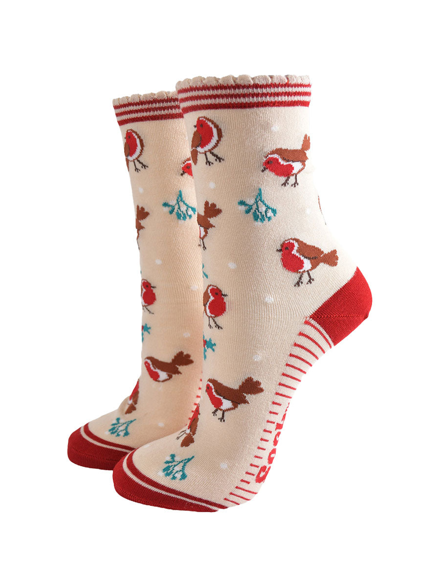 cream socks with a red striped cuff with a pattern of red robin birds, mistletoe and holly all over