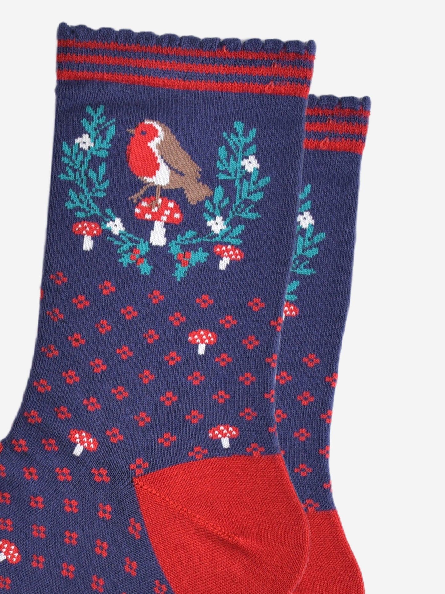 close up of the red robin and festive holly wreath on the ankle of the socks, the robin is perched on a red toadstool in the centre of the wreath, the wreath is horseshoe shaped and does not fully enclose the robin