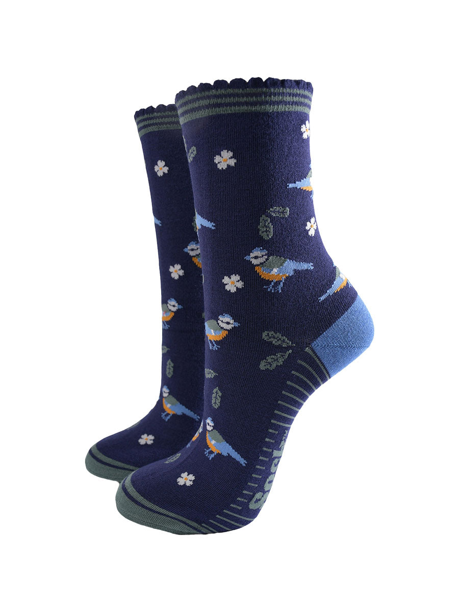 navy blue ankle socks with a pattern of blue tit garden birds, leaves and flowers, the socks have a striped green scalloped cuff