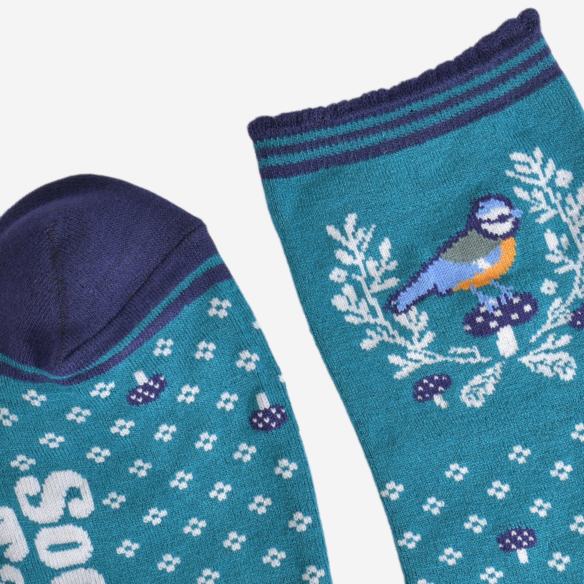 close up of the toe and cuff of the socks, the toe is navy blue in contrast to the light blue of the socks, the cuff is scalloped and is striped light blue and navy blue