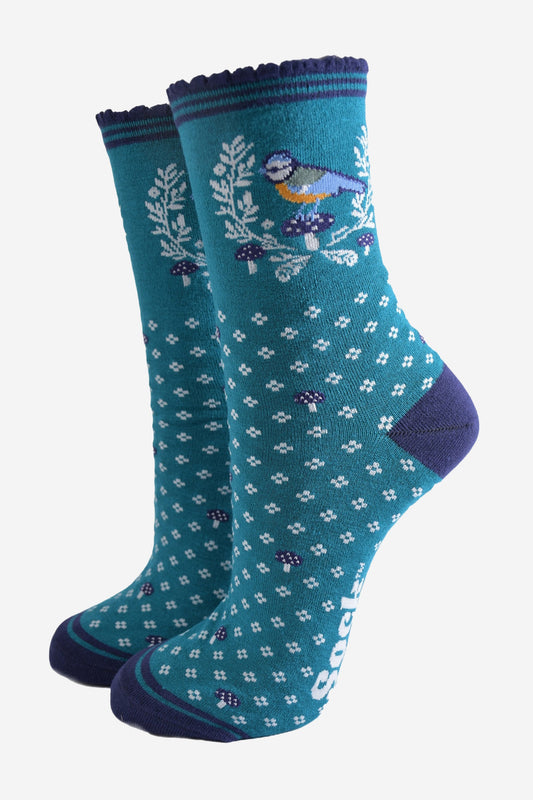 teal blue ankle socks with a navy scalloped cuff with a pattern of blue tit birds, floral wreath and blue toadstools