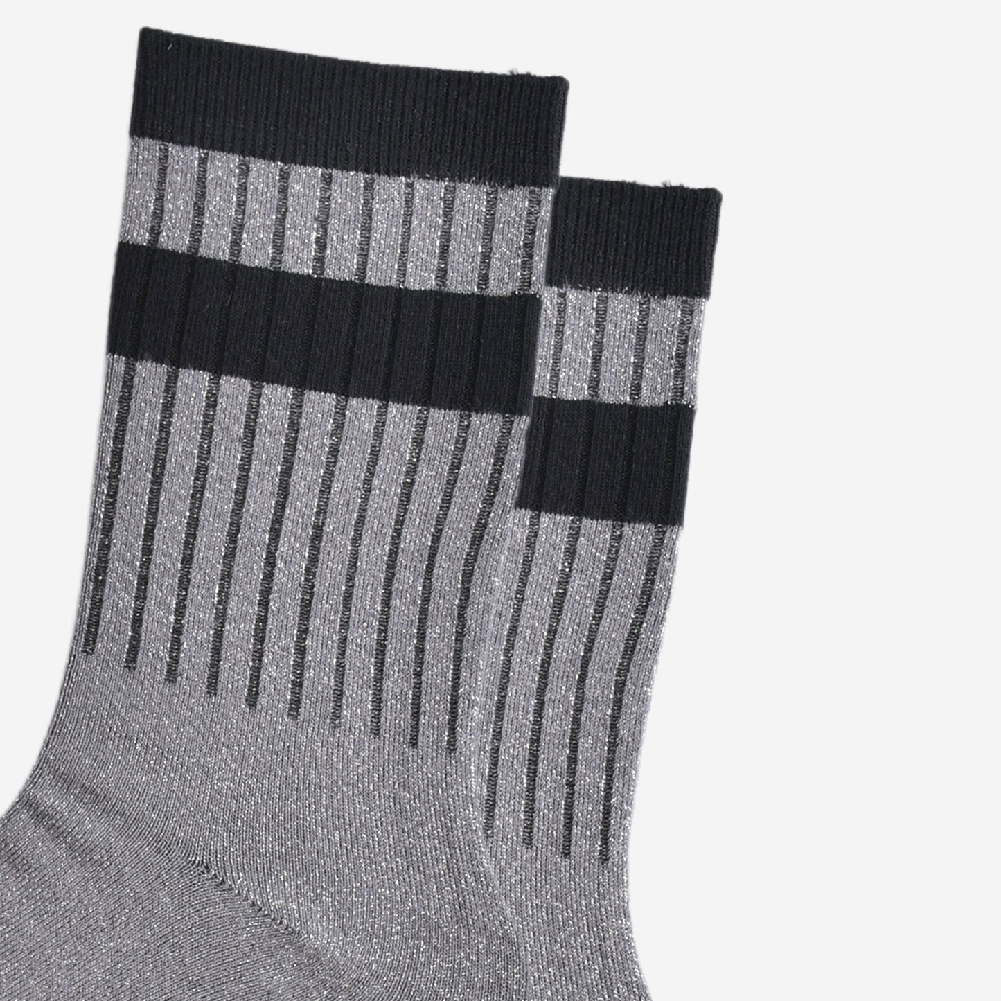 close up of the ribbed sports style cuffs on the socks. they have vertical ribbed details. the base of the socks are grey with a silver glitter sparkle. the cuff is black and there is a horizontal black band stripe, without glitter an inch below the cuff. 