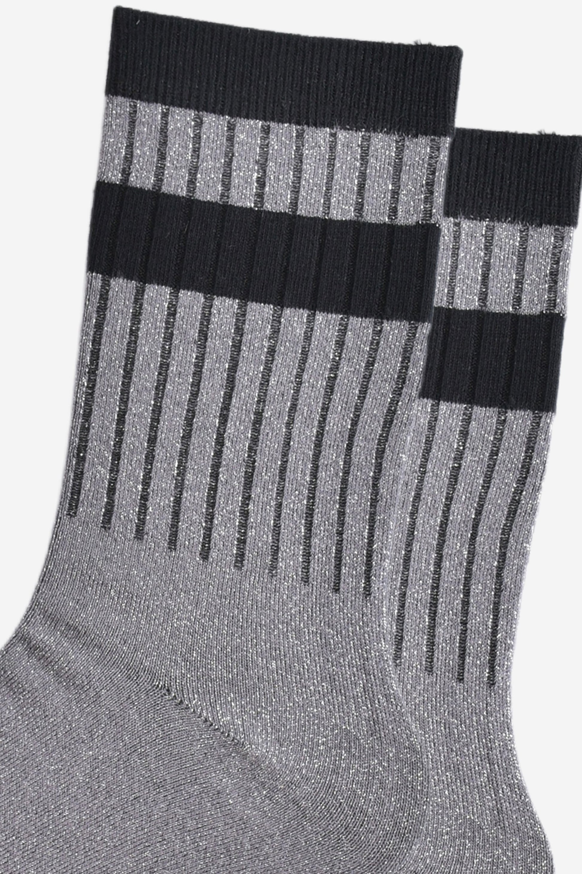 close up of the ribbed sports style cuffs on the socks. they have vertical ribbed details. the base of the socks are grey with a silver glitter sparkle. the cuff is black and there is a horizontal black band stripe, without glitter an inch below the cuff. 