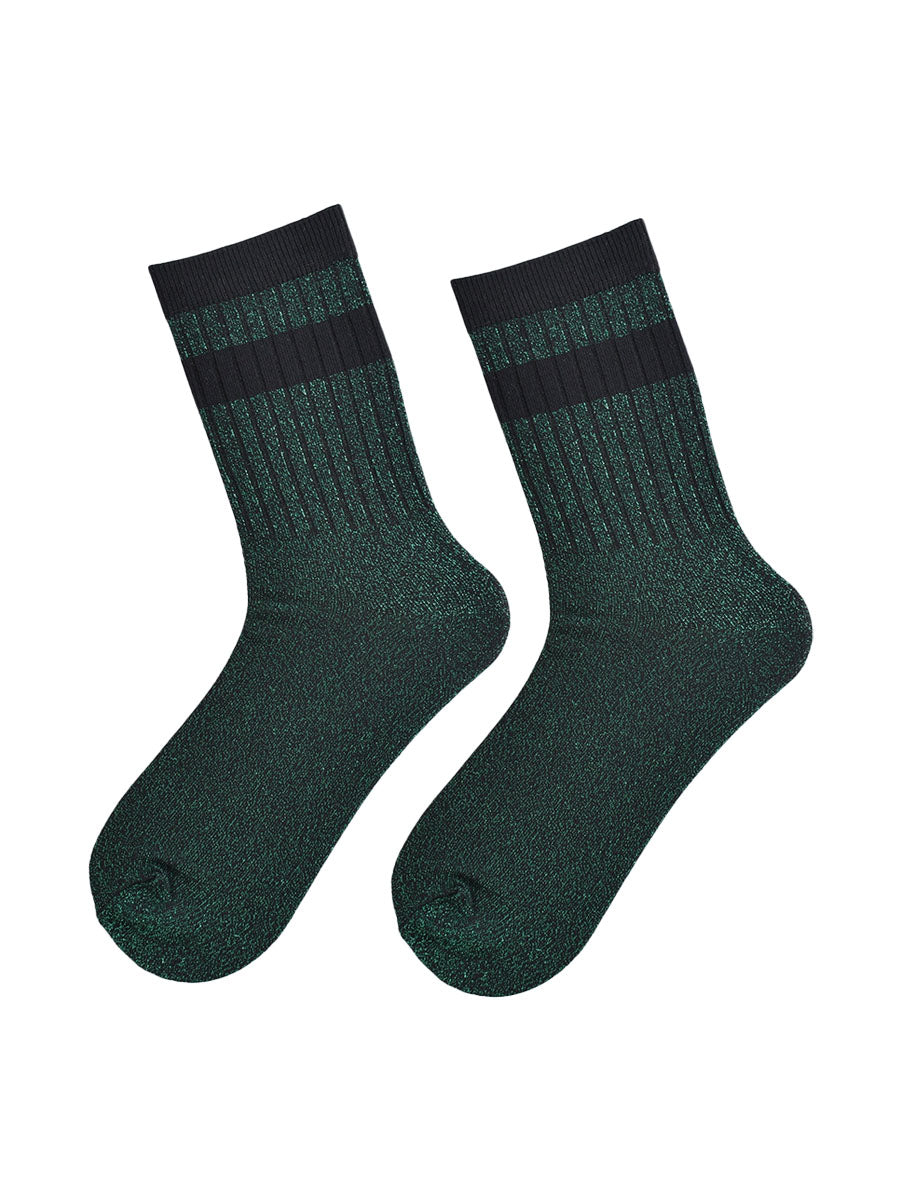showing the socks laying flat, they have an all over green and silver glitter sparkle, ribbed cuffs and black striped bands on the cuff and ankle
