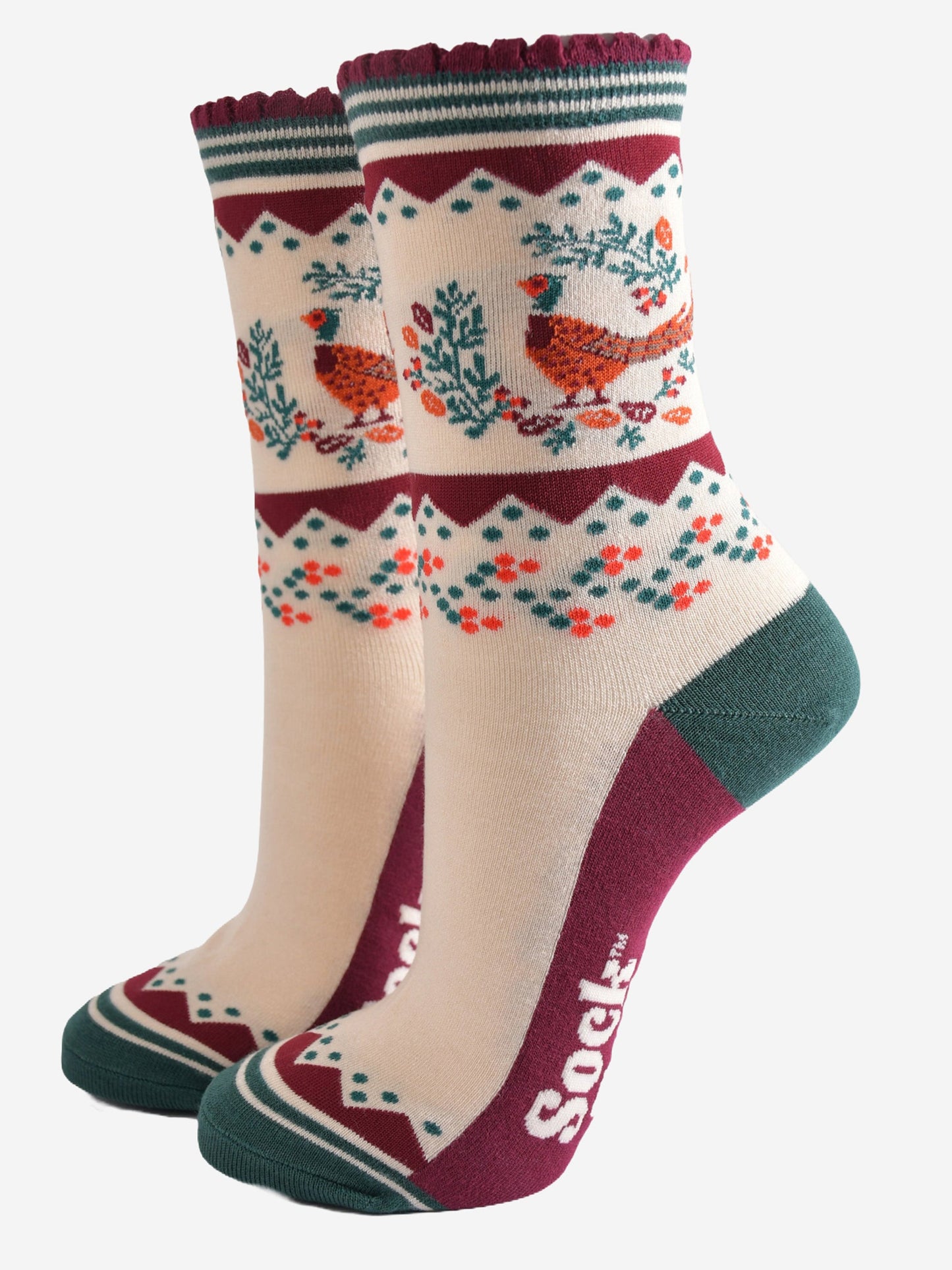 cream, green and burgundy socks with a woodland pheasant and autumn foliage wreath on the ankle