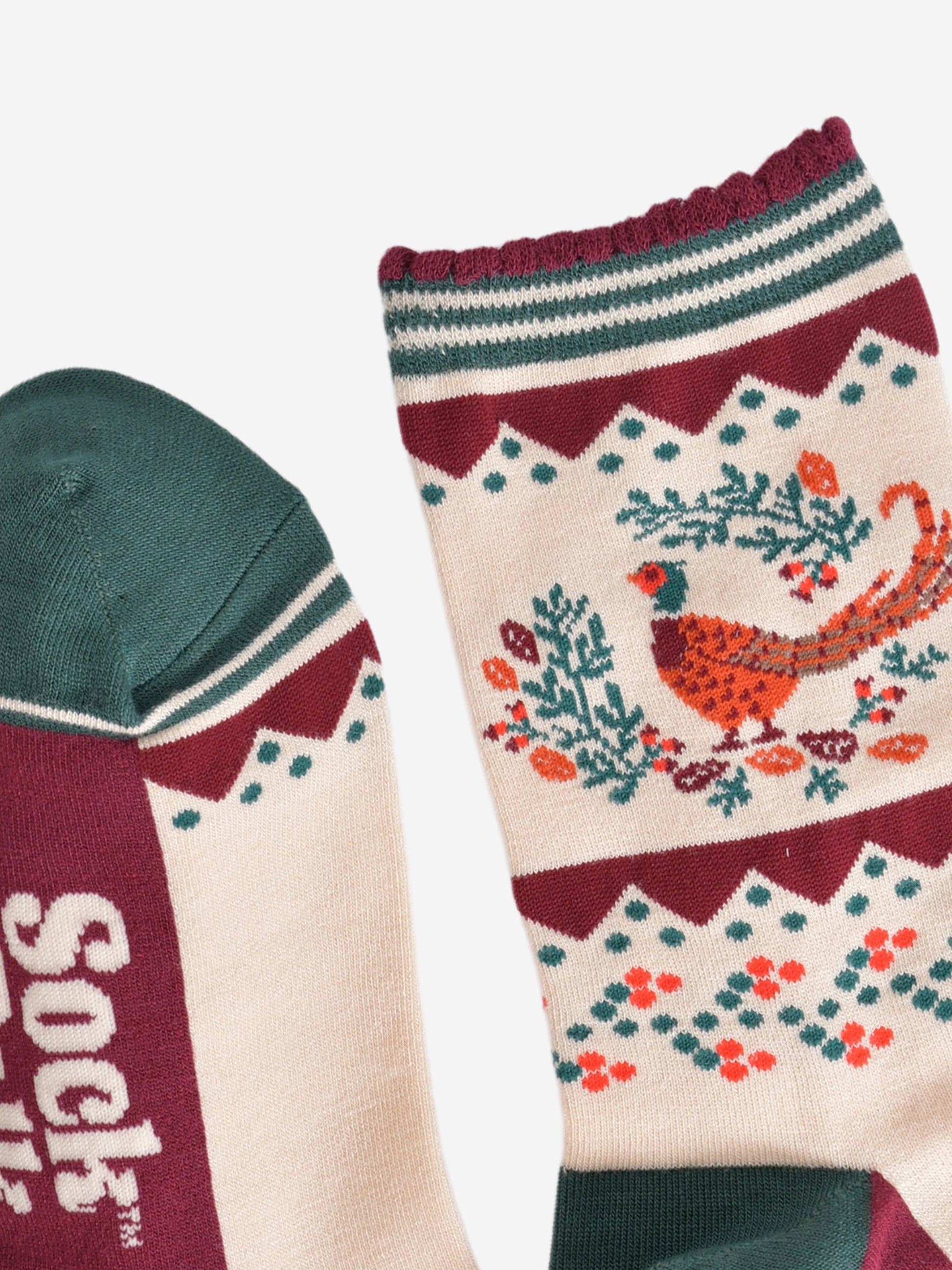 close up of the toe and cuff of the socks, the toe is green with a cream striped outline, the cuff is scalloped with a burgundy edge and green and cream striped pattern