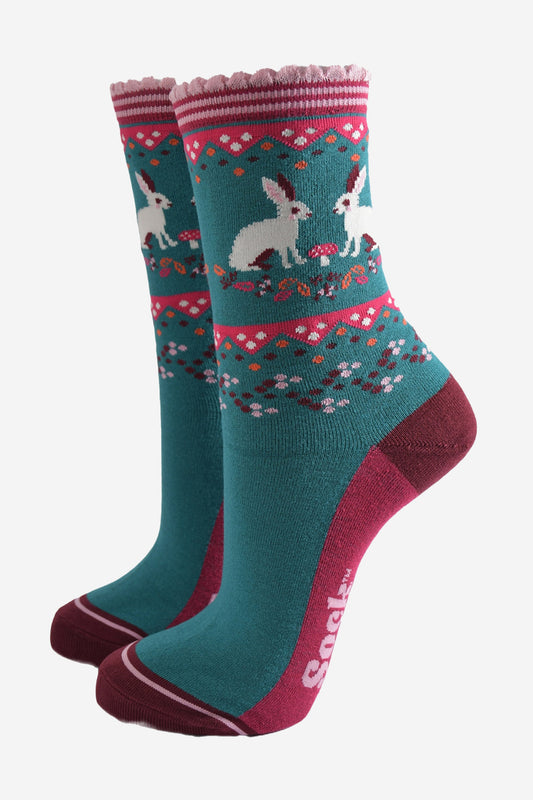 green and burgundy bamboo socks with a pattern of white rabbits, autumn leaves and pink toadstools on the ankles of the socks