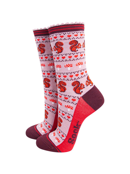 pink socks with a fair isle style pattern featuring toadstools, red love hearts and squirrels