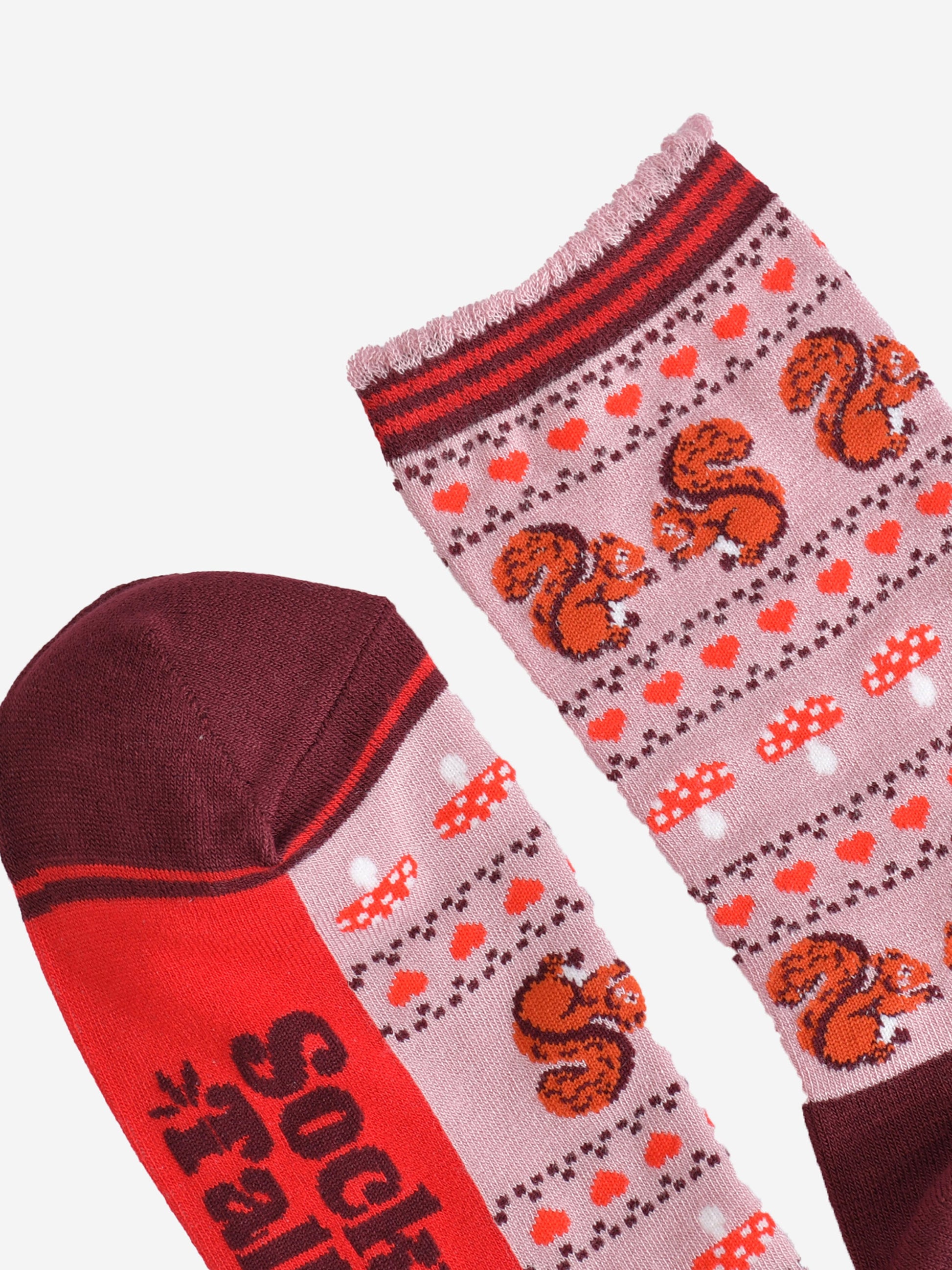 close up of the toe and cuff of the socks, the toe is burgundy with a red striped outline, the cuff is scalloped with a light pink edge and red and burgundy striped trim