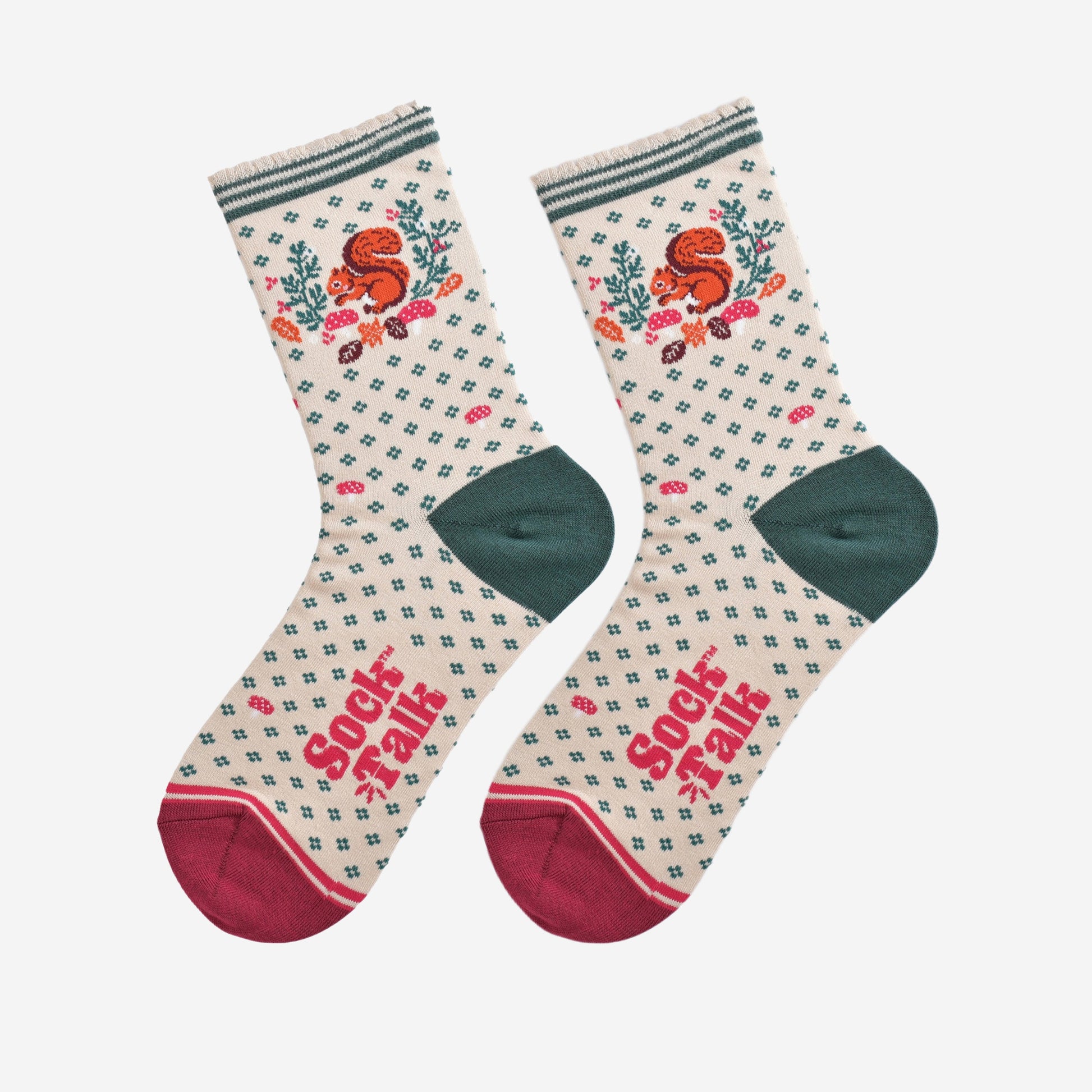 cream and green squirrel wreath socks laying flat, showing the all over green floral pattern and dominant red squirrel and wreath design on the ankle of the socks