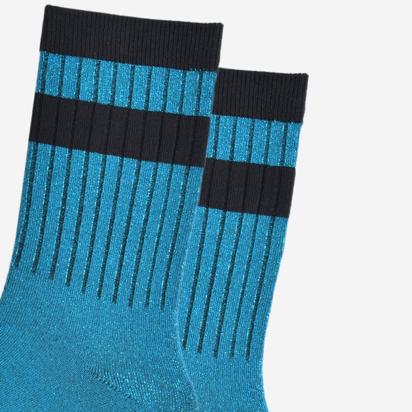 close up of the ribbed sports style cuffs on the socks. they have vertical ribbed details. the base of the socks are teal blue with a silver glitter sparkle. the cuff is black and there is a horizontal black band stripe, without glitter an inch below the cuff. 