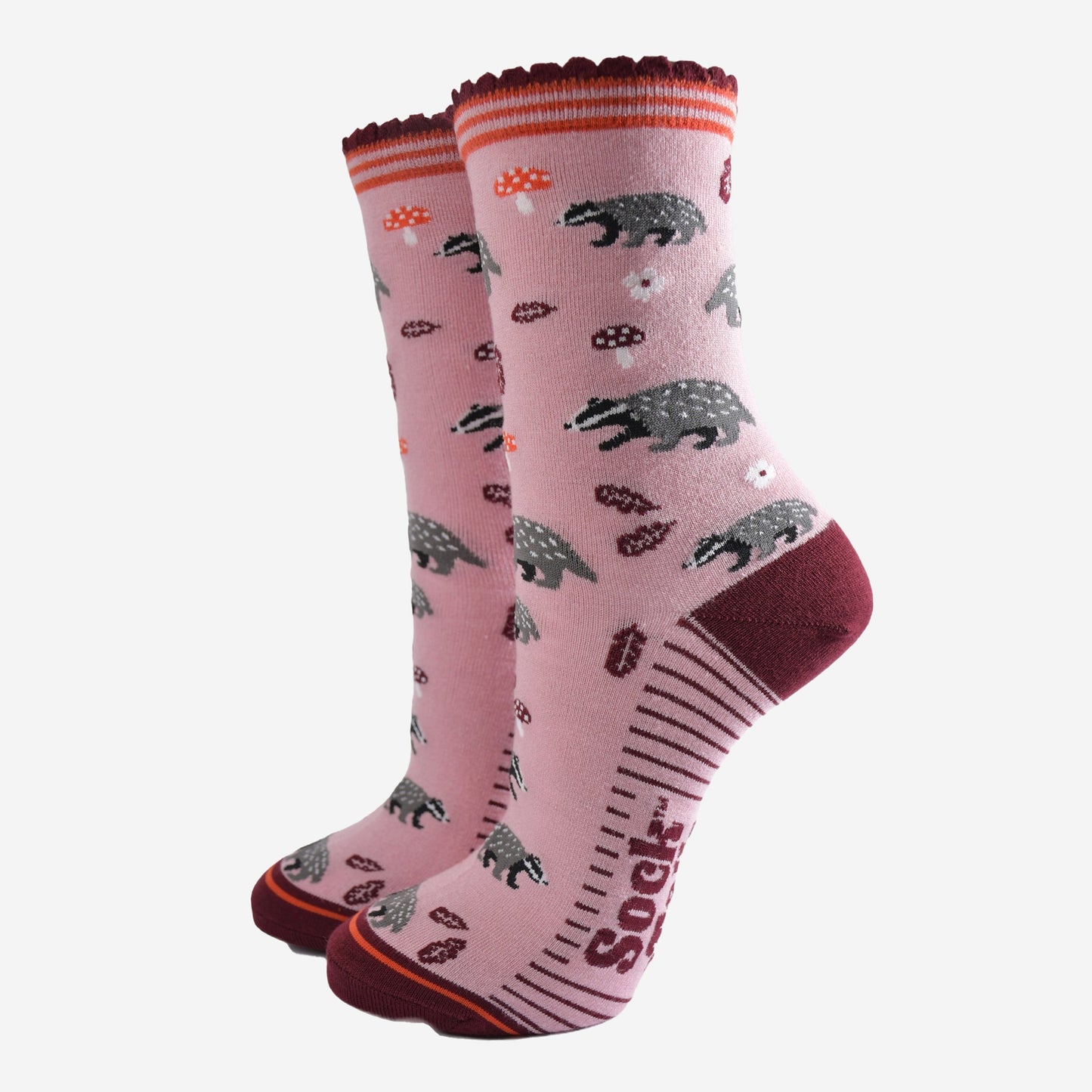 pink socks with a pattern of woodland badgers, flowers and toadstools