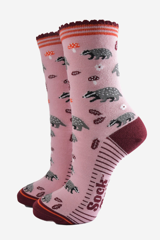 pink socks with a pattern of woodland badgers, flowers and toadstools