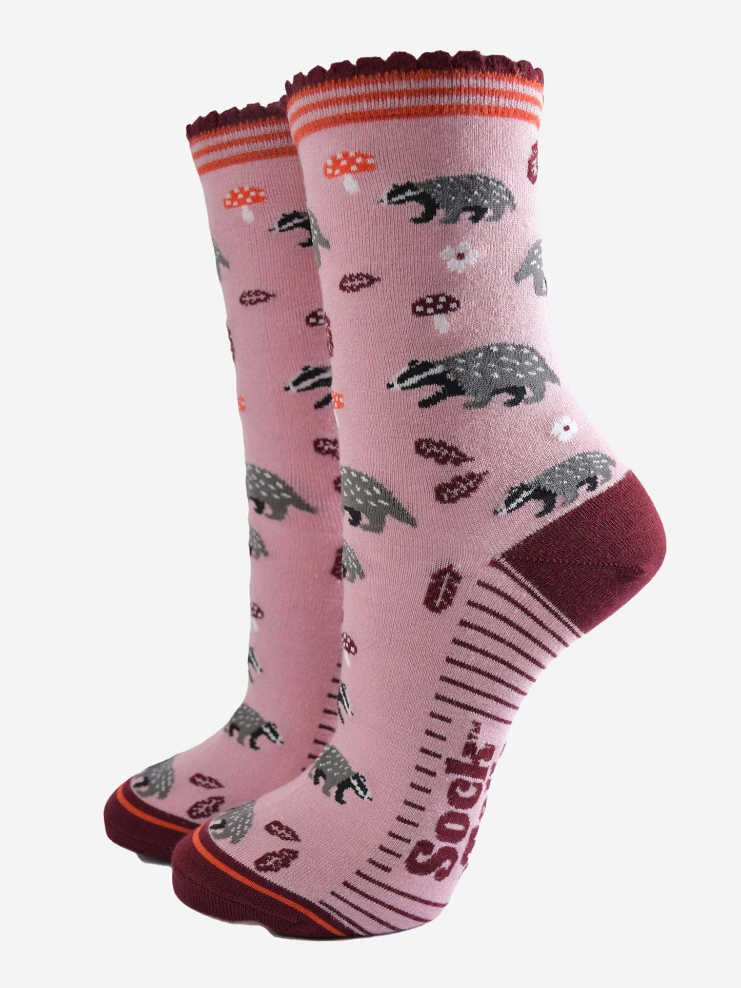 pink socks with a pattern of woodland badgers, flowers and toadstools