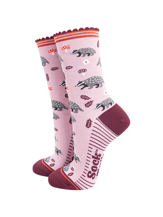 pink socks with a pattern of woodland badgers, flowers and toadstools