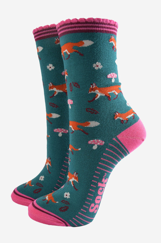 green socks with pink accents and an all over pattern featuring red foxes and toadstools