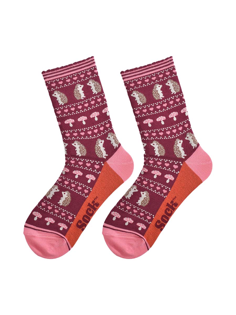 showing the fair isle hedgehog socks laying flat, highlighting the all over pattern featuring hedgehogs, toadstools and pink love hearts