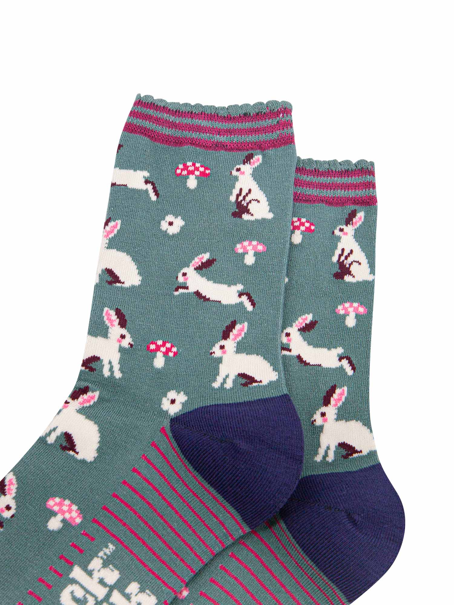 close up of the white rabbit design, the rabbits are sitting, hopping and standing, they have pink rosy cheeks and pink inner ears. there are pink and white toadstools and white flowers scattered around the design.