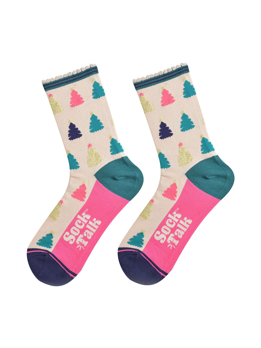 showing the christmas tree socks laying flat, the sole is hot pink in contrast to the cream body of the socks. the xmas tree pattern is all over an in a variety of colours, pink, gold, blue and green