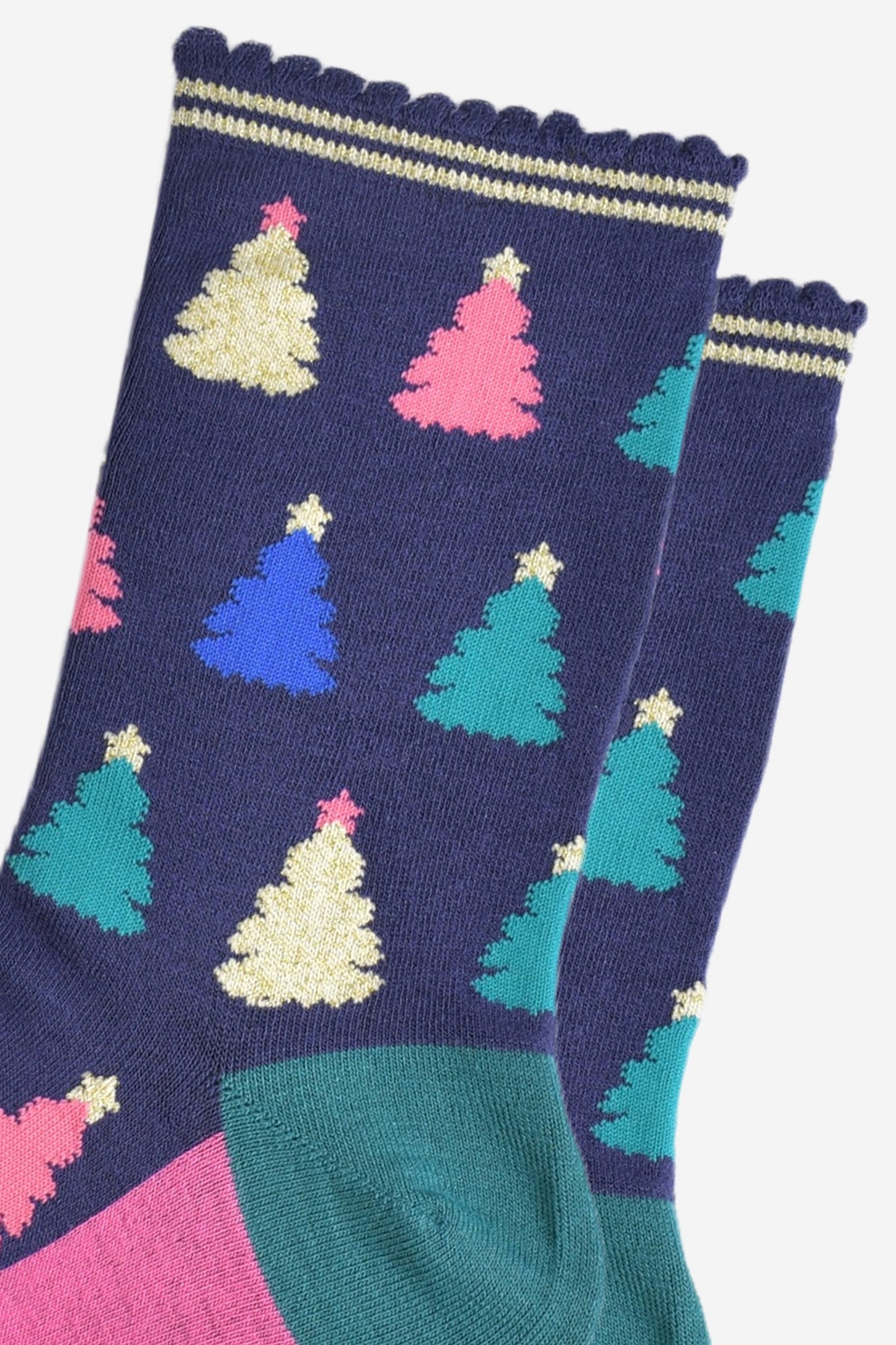 close up of the colourful christmas tree pattern, there are gold, pink, green and blue trees each with stars on the top