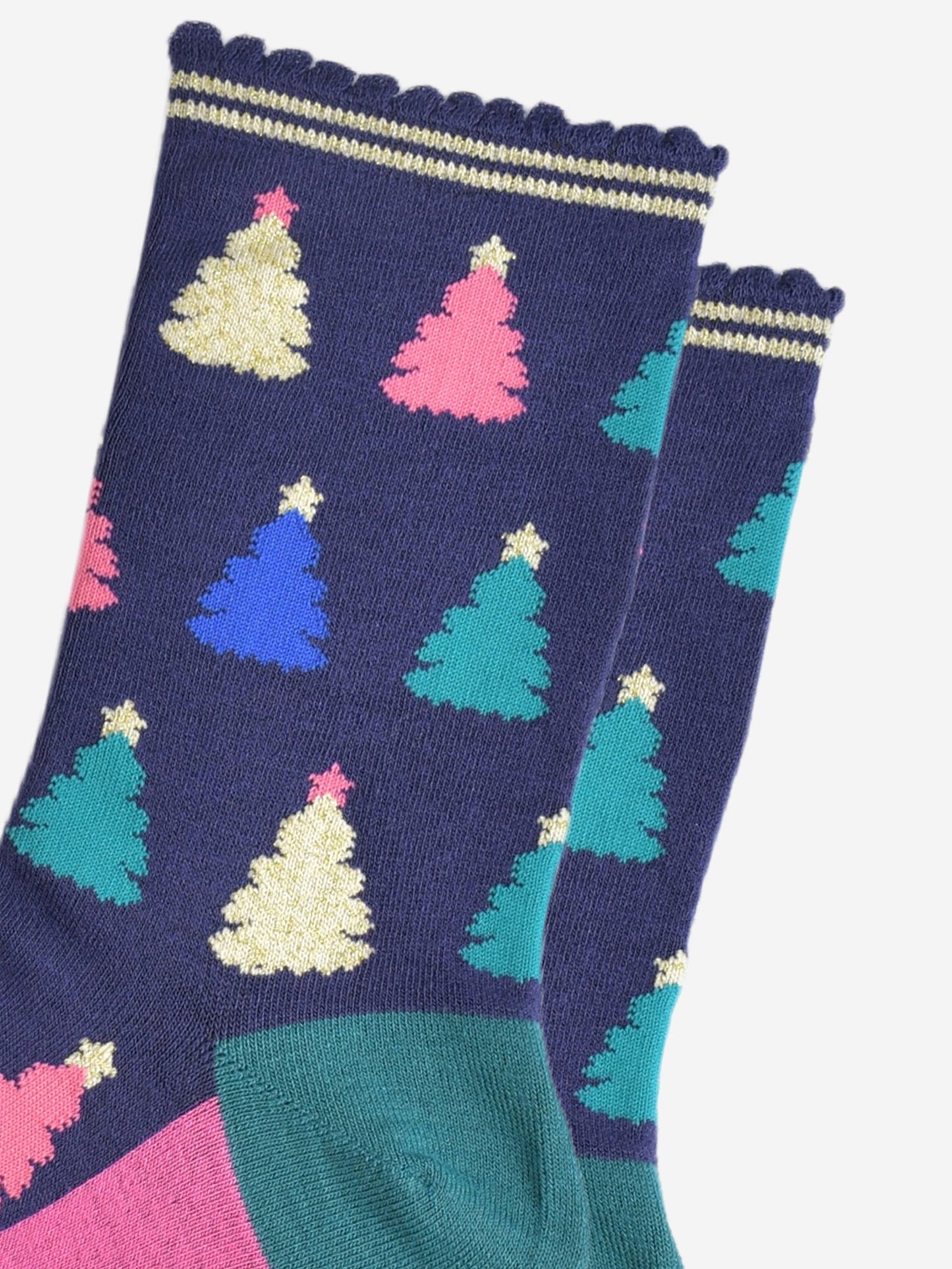 close up of the colourful christmas tree pattern, there are gold, pink, green and blue trees each with stars on the top