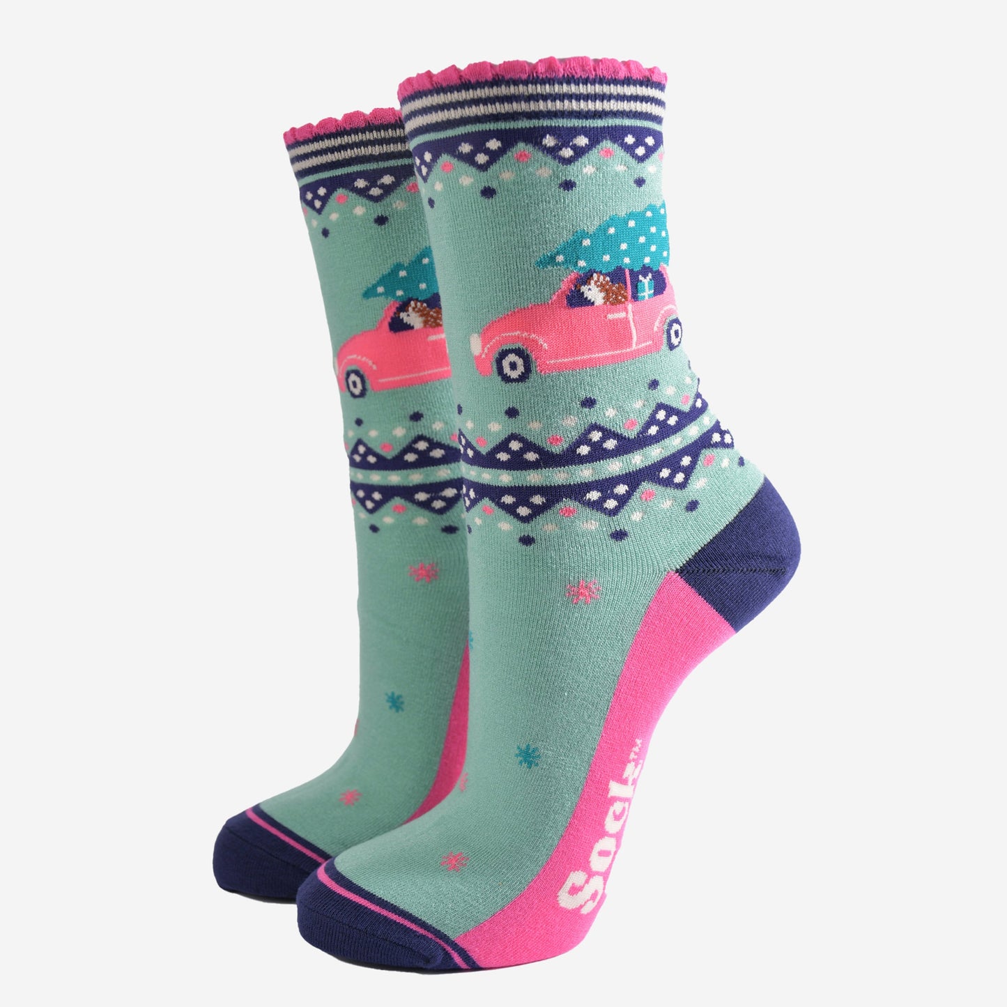 mint green bamboo socks with pink and navy blue accents, on the ankle of the sock there is a hedgehog driving a pink car with a christmas tree on its roof