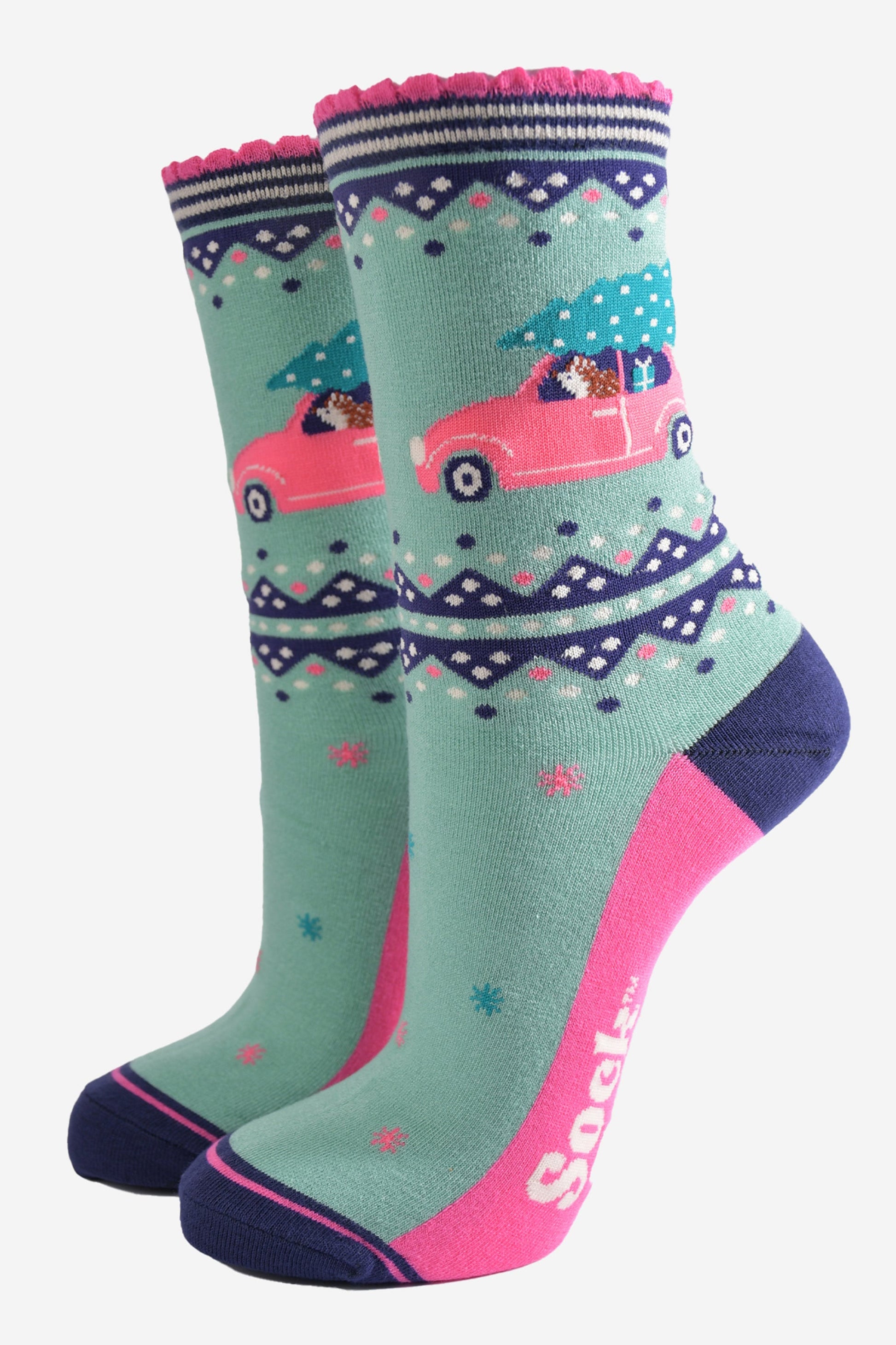 mint green bamboo socks with pink and navy blue accents, on the ankle of the sock there is a hedgehog driving a pink car with a christmas tree on its roof