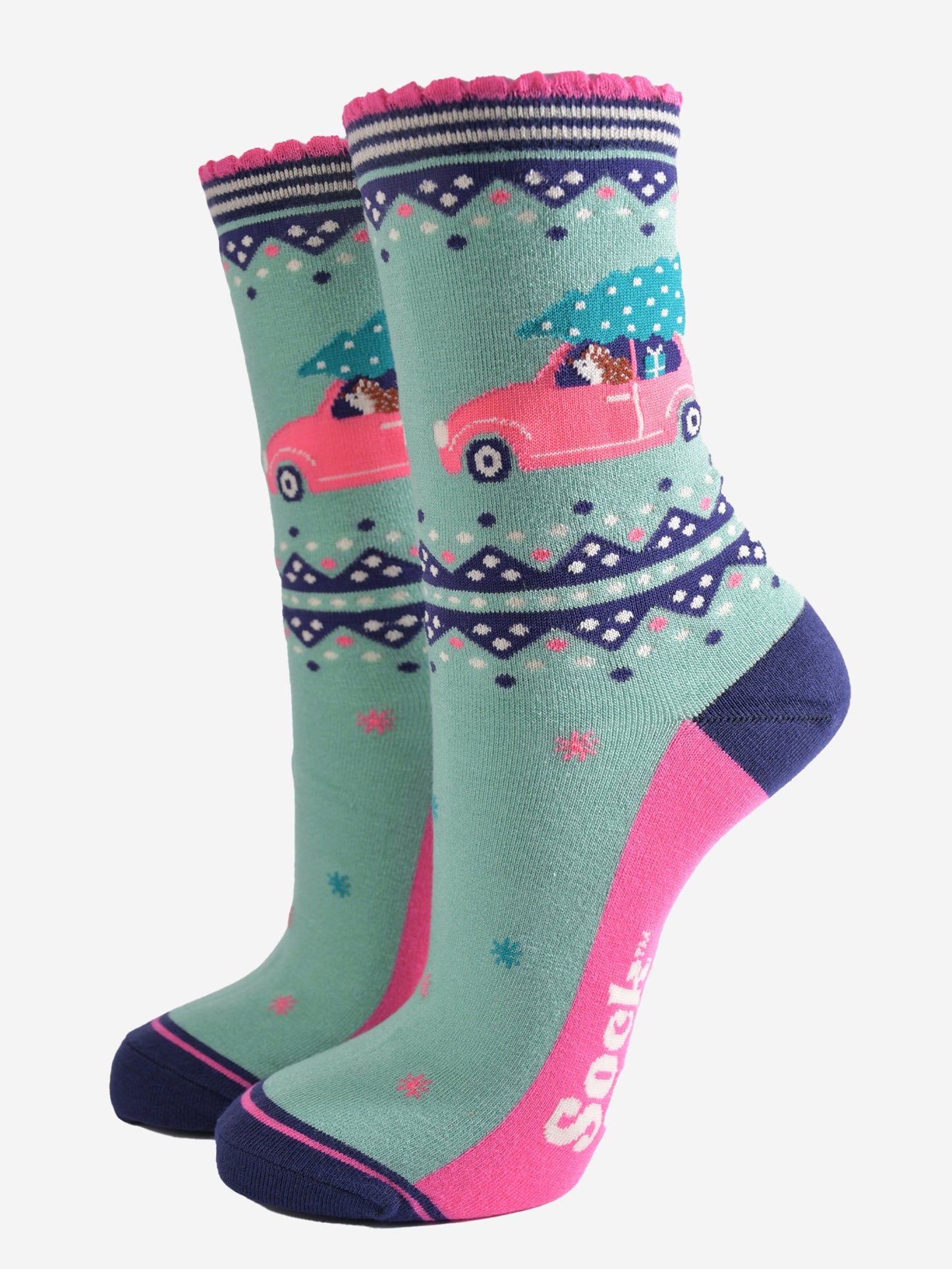 mint green bamboo socks with pink and navy blue accents, on the ankle of the sock there is a hedgehog driving a pink car with a christmas tree on its roof