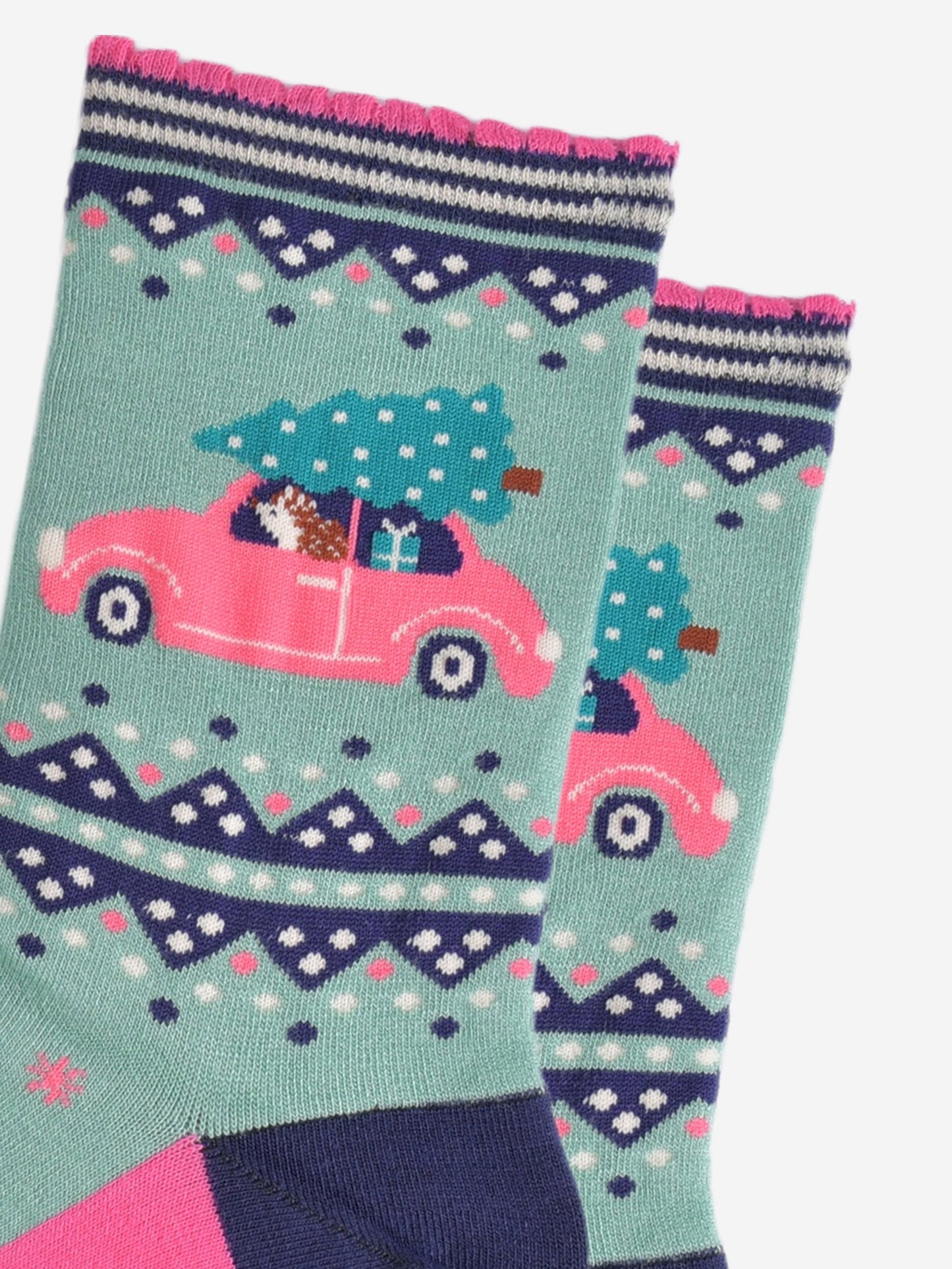 close up of the hedgehog diving the car, the car is pink and has a christmas tree on the roof and a christmas gift on the back seat