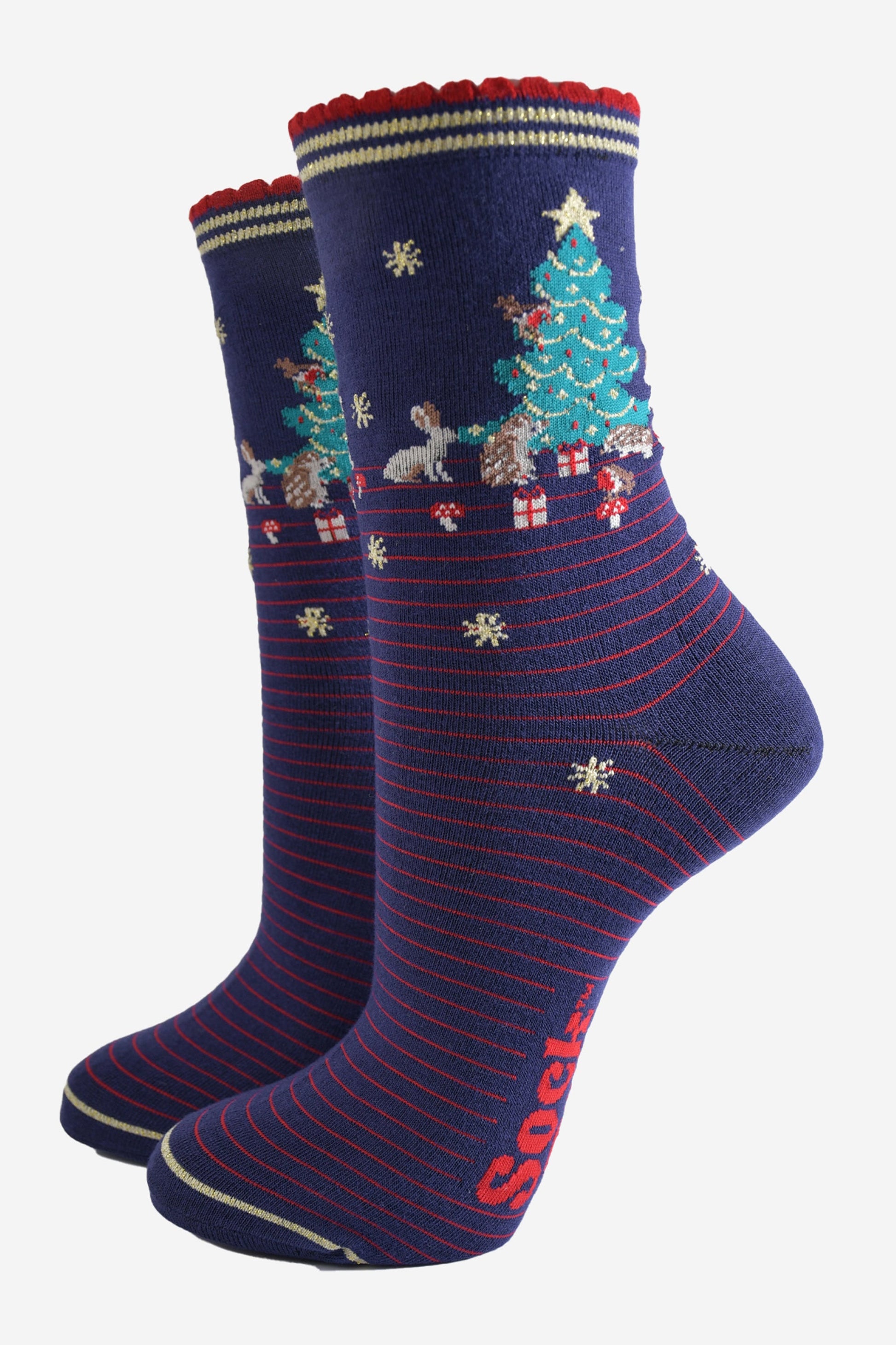 navy blue socks with red pinstripes. on the ankle of the socks there is a green xmas tree surrounded by rabbits, hedgehogs and toadstools