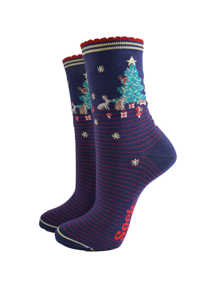 navy blue socks with red pinstripes. on the ankle of the socks there is a green xmas tree surrounded by rabbits, hedgehogs and toadstools