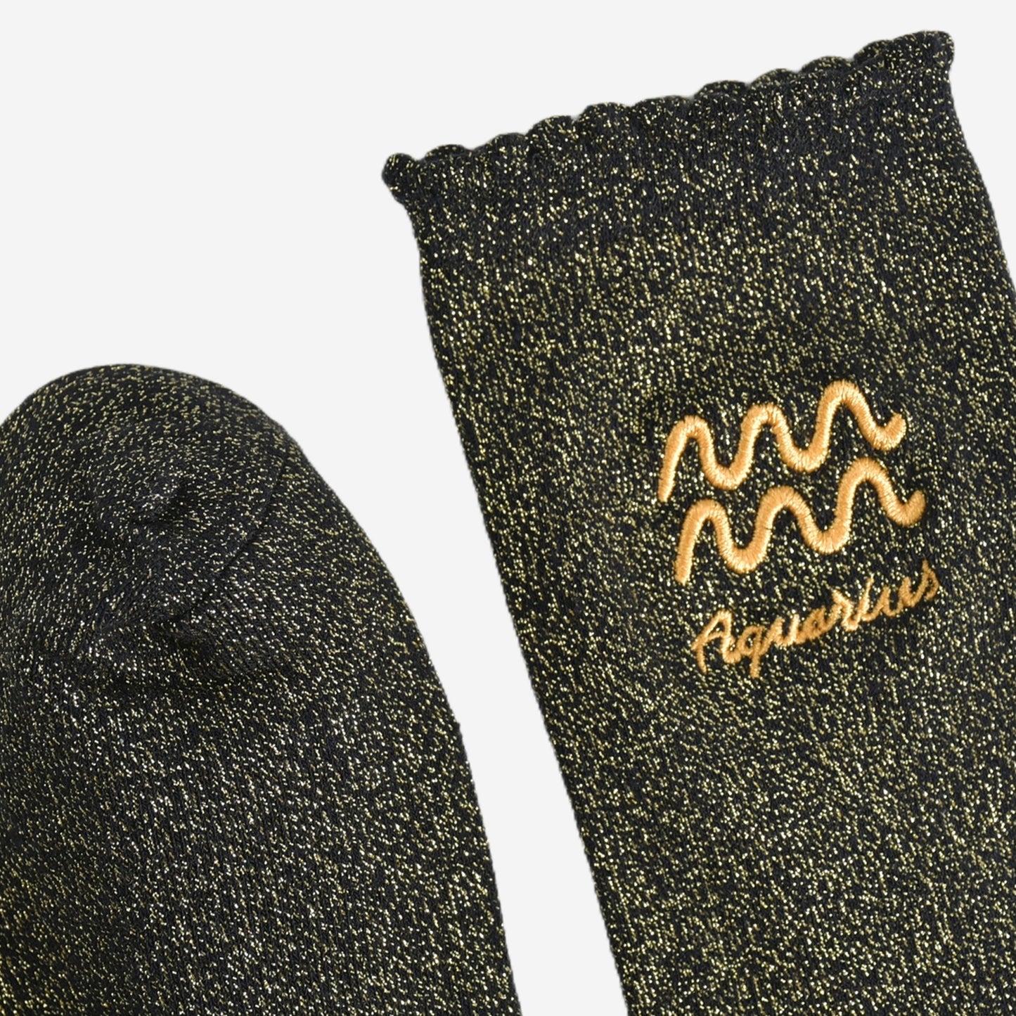 showing the toe and cuff of the socks, they are the same black and gold sparkly colour as the body of the socks, the cuff is scalloped shaped like a slight frill