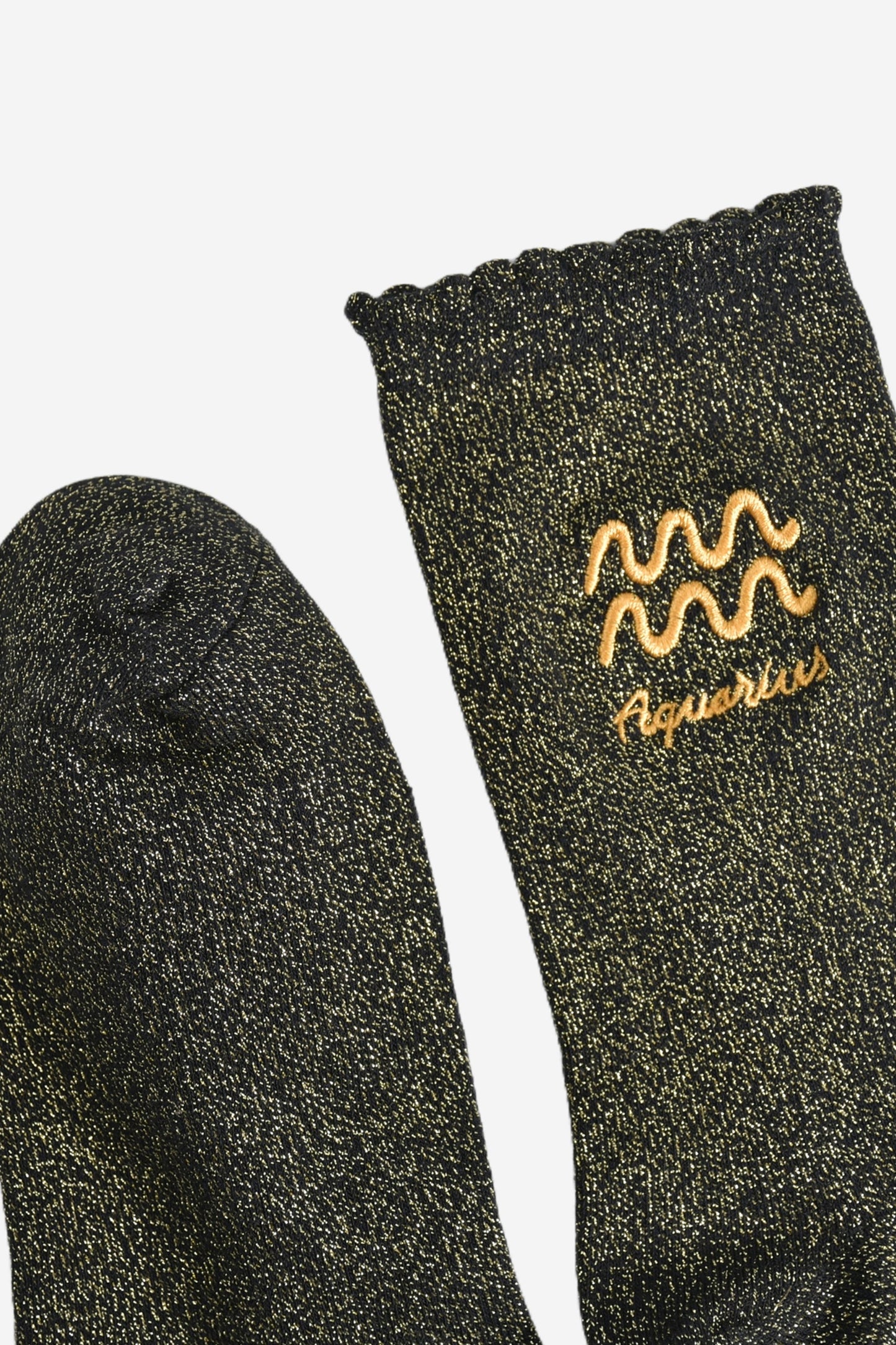 showing the toe and cuff of the socks, they are the same black and gold sparkly colour as the body of the socks, the cuff is scalloped shaped like a slight frill