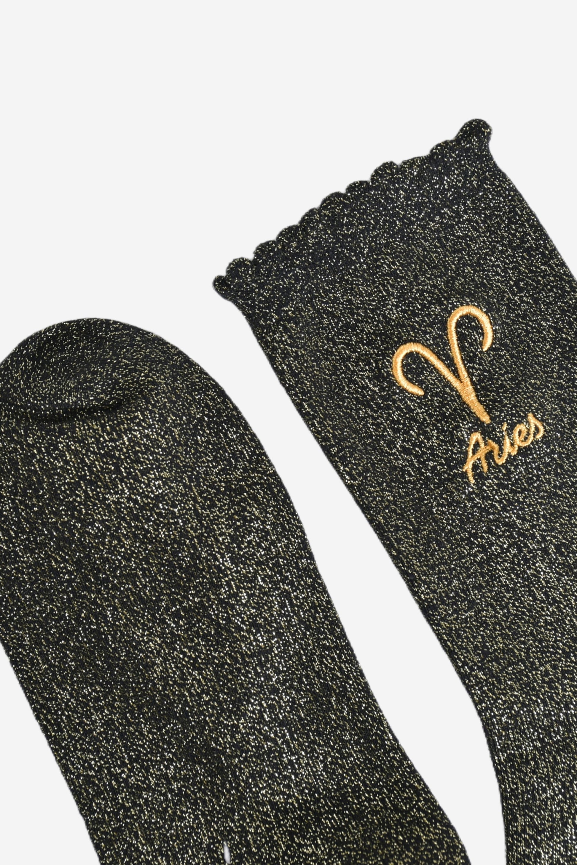 showing the toe and cuff of the socks, they are the same black and gold sparkly colour as the body of the socks, the cuff is scalloped shaped like a slight frill